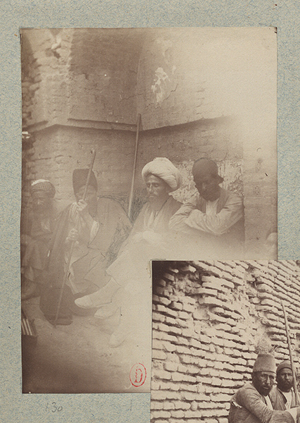 A group of men sit in an arched niche.